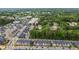 Aerial view of a neighborhood with trees, businesses, and rows of colorful townhomes at 433 Triumph Ln, Wake Forest, NC 27587