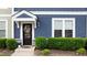 Charming front door with wreath, blue siding and neatly trimmed hedges at 433 Triumph Ln, Wake Forest, NC 27587