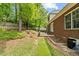 Backyard with a brick house, some green space, and the perimeter is fenced in with a white fence at 480 Whitt Ave, Burlington, NC 27215