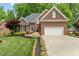 Charming brick home featuring a manicured lawn, attached two car garage, and lush landscaping at 480 Whitt Ave, Burlington, NC 27215