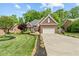 Charming brick home featuring a manicured lawn, attached two car garage, and lush landscaping at 480 Whitt Ave, Burlington, NC 27215