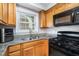Well-lit kitchen features granite counters, stainless steel sink, and gas range at 4822 Blue Bird Ct # B, Raleigh, NC 27606