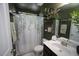 Green bathroom featuring a shower with botanical shower curtain, and modern vanity at 49 Pumpkin Hill Rdg, Clayton, NC 27520