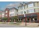 Townhouses with brick and tan exteriors, green shutters, black awnings, and sidewalks with benches at 49 Pumpkin Hill Rdg, Clayton, NC 27520