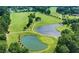 Aerial view of a lush golf course with ponds and tree lined fairways at 49 Pumpkin Hill Rdg, Clayton, NC 27520
