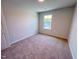 Neutral bedroom featuring a window, carpet, and white trim at 499 Beacon Hill Rd # 30, Lillington, NC 27546