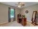 Neutral bedroom features a ceiling fan, modern desk, decor mirror and natural light from the window at 500 Lemontree Ct, Graham, NC 27253