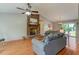 Open living room with a brick fireplace, hardwood floors, and vaulted ceilings at 500 Lemontree Ct, Graham, NC 27253