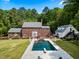 Aerial view of backyard featuring in-ground pool, poolhouse, and lush landscaping at 500 Old Greensboro Rd, Chapel Hill, NC 27516