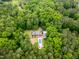 Stunning aerial view of a secluded home surrounded by lush forest with an in-ground pool at 500 Old Greensboro Rd, Chapel Hill, NC 27516