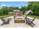 Backyard with stone-trimmed pool, fire pit and exterior seating area viewed from the manicured lawn at 500 Old Greensboro Rd, Chapel Hill, NC 27516