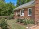 Landscaped backyard of a brick home featuring a rose garden and well-manicured lawn at 500 Old Greensboro Rd, Chapel Hill, NC 27516