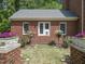 Red brick home with a charming backyard featuring rose bushes and lush green grass at 500 Old Greensboro Rd, Chapel Hill, NC 27516