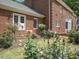 Brick home exterior with lush rose bushes and manicured lawn at 500 Old Greensboro Rd, Chapel Hill, NC 27516