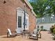 Brick patio with outdoor seating, connected to the primary structure and an adjacent building with a manicured lawn at 500 Old Greensboro Rd, Chapel Hill, NC 27516