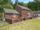 Exterior view showcases a brick home with manicured backyard and garden at 500 Old Greensboro Rd, Chapel Hill, NC 27516
