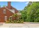 Back of brick house featuring a basketball court and meticulously landscaped flower beds at 500 Old Greensboro Rd, Chapel Hill, NC 27516