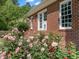 A rose garden and a brick wall adjacent to the house exterior at 500 Old Greensboro Rd, Chapel Hill, NC 27516