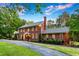 Elegant two-story brick home with manicured lawn and charming architectural details at 500 Old Greensboro Rd, Chapel Hill, NC 27516