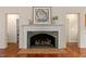 Living room with white fireplace, brick hearth, hardwood floors, and neutral colors at 500 Old Greensboro Rd, Chapel Hill, NC 27516