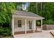 Charming pool house featuring a covered porch, perfect for relaxation and enjoying the outdoor space at 500 Old Greensboro Rd, Chapel Hill, NC 27516