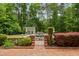 Backyard pool area with stone-trimmed pool, manicured hedges and landscaping, and an adjacent pool house at 500 Old Greensboro Rd, Chapel Hill, NC 27516