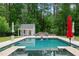 Backyard pool with stone trim, adjacent pool house, and landscaped area surrounded by mature trees at 500 Old Greensboro Rd, Chapel Hill, NC 27516