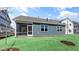 View of the home's blue exterior with a screened porch and a freshly sodded backyard at 552 Lemon Daisy Ln, Knightdale, NC 27545