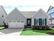 Charming home featuring vertical siding, black window shutters, a two-car garage, and a well-manicured front lawn at 552 Lemon Daisy Ln, Knightdale, NC 27545