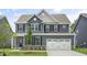Charming two-story home with gray siding, black shutters, and a well-manicured front yard, perfect for curb appeal at 556 Lemon Daisy Ln, Knightdale, NC 27545