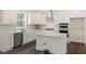Modern white kitchen with stainless steel appliances, a center island, and elegant countertops for a sleek design at 556 Lemon Daisy Ln, Knightdale, NC 27545