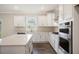 Well-equipped kitchen with white cabinets, stainless steel appliances, a center island, and stylish backsplash at 556 Lemon Daisy Ln, Knightdale, NC 27545