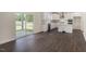 Open-concept living area featuring a sliding glass door, white kitchen, and hardwood floors at 556 Lemon Daisy Ln, Knightdale, NC 27545