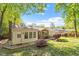 Backyard of brick house featuring mature trees and landscaping at 5713 Old Forge Cir, Raleigh, NC 27609