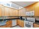 Kitchen with natural wood cabinets and stainless steel appliances, complemented by a tiled backsplash at 5713 Old Forge Cir, Raleigh, NC 27609