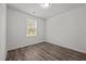Bright bedroom featuring wood-look flooring, a window with blinds, and neutral walls at 6007 Austin Falls Ct, Liberty, NC 27298