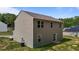 Rear view of the two-story home with neutral siding and a sliding door to the backyard at 6007 Austin Falls Ct, Liberty, NC 27298