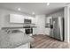 Modern kitchen featuring stainless steel appliances, granite countertops, and white cabinets at 6007 Austin Falls Ct, Liberty, NC 27298