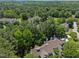 Drone shot of the condo community shows pool, rooflines, parking, landscaping, and surrounding woods at 6120 Sunpointe Dr # 102, Raleigh, NC 27606