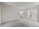 Bright bedroom features neutral paint and carpet, lamp and doorway leading to other rooms at 6120 Sunpointe Dr # 102, Raleigh, NC 27606