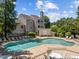 Community pool has lounge chairs and tables surrounding it, with an adjacent building and fence at 6120 Sunpointe Dr # 102, Raleigh, NC 27606
