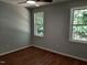 A cozy bedroom, with two windows, featuring wood-look flooring and a neutral wall color at 640 Sagamore Dr, Louisburg, NC 27549