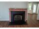 Close up of living room fireplace, featuring a brick surround, black hearth, and wood-look flooring at 640 Sagamore Dr, Louisburg, NC 27549