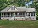 Charming single Gathering home boasting a cozy front porch, complemented by lush landscaping and mature trees at 640 Sagamore Dr, Louisburg, NC 27549
