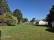 A sprawling backyard surrounded by mature trees and a chain link fence, featuring a basketball hoop on the left at 66 Epsom Rocky Ford Rd, Henderson, NC 27537
