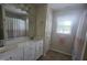 Neutral bathroom featuring a double vanity, tiled floors, and a shower with a colorful curtain at 66 Epsom Rocky Ford Rd, Henderson, NC 27537