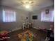 Bedroom featuring hardwood floors, two windows, and play area at 66 Epsom Rocky Ford Rd, Henderson, NC 27537