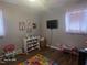 Bedroom featuring hardwood floors, two windows, and a play area at 66 Epsom Rocky Ford Rd, Henderson, NC 27537