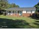 Charming single-story home featuring a brick foundation, light-colored siding, and a covered porch, perfect for relaxing at 66 Epsom Rocky Ford Rd, Henderson, NC 27537