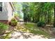 Well-maintained backyard with mature trees, lush greenery, and gated access to a wooded area at 71 Potted Plant Ct, Clayton, NC 27520